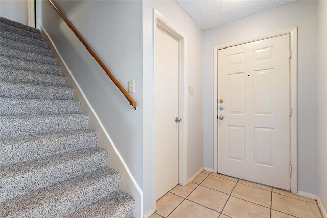 tiled foyer entrance with a textured ceiling