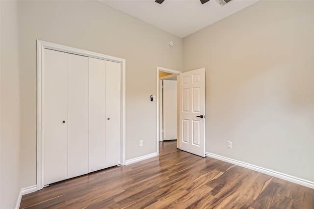 unfurnished bedroom featuring dark hardwood / wood-style flooring, a closet, and ceiling fan