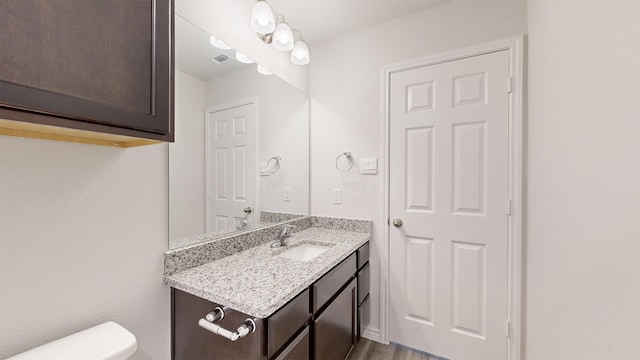 bathroom featuring vanity, toilet, and hardwood / wood-style flooring