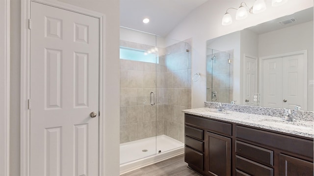 bathroom featuring walk in shower, vanity, vaulted ceiling, and hardwood / wood-style flooring