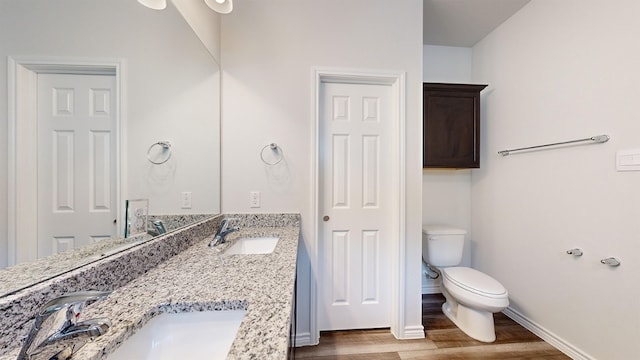 bathroom with wood-type flooring, vanity, and toilet