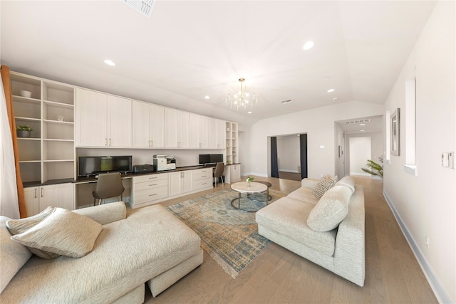 living room featuring light hardwood / wood-style flooring, built in desk, vaulted ceiling, and a chandelier