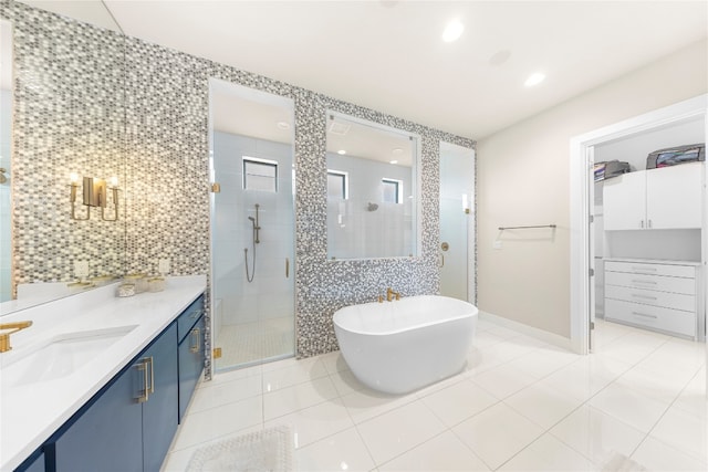 bathroom featuring independent shower and bath, vanity, tile walls, and tile patterned flooring