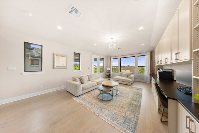 living room featuring light wood-type flooring and a chandelier