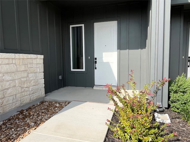 entrance to property featuring stone siding and board and batten siding