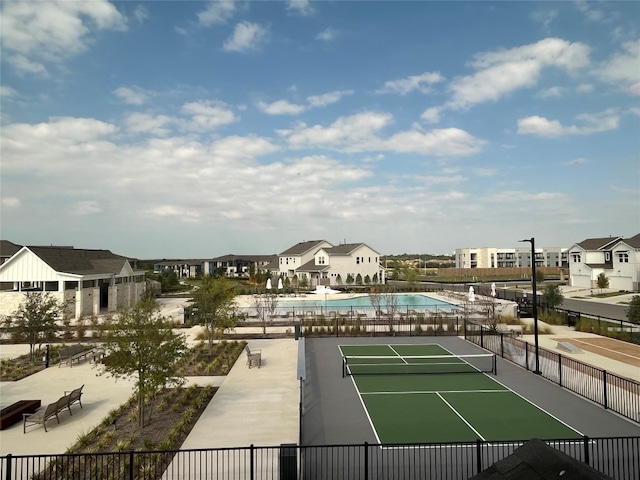 view of tennis court with a community pool