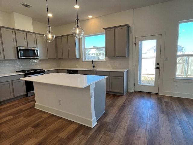 kitchen with gray cabinetry, a sink, visible vents, appliances with stainless steel finishes, and tasteful backsplash