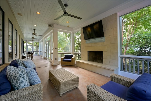 sunroom with lofted ceiling, wood ceiling, a large fireplace, and ceiling fan