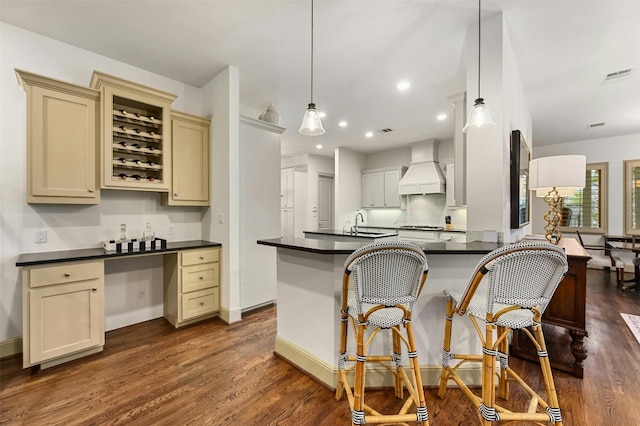 14 Margranita Cres, Austin, TX 78703 - kitchen with custom exhaust hood, dark countertops, cream cabinets, dark wood-style floors, and recessed lighting