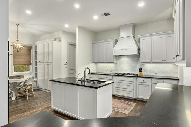 kitchen featuring hanging light fixtures, white cabinetry, dark hardwood / wood-style flooring, custom exhaust hood, and sink