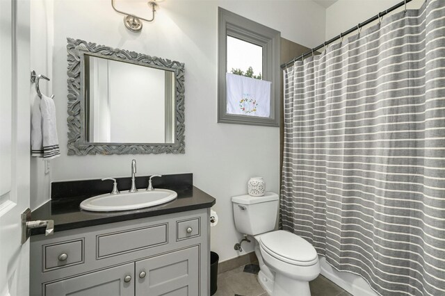 bathroom featuring tile patterned floors, walk in shower, vanity, and toilet