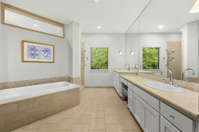 bathroom with double vanity, a wealth of natural light, a shower stall, and a sink