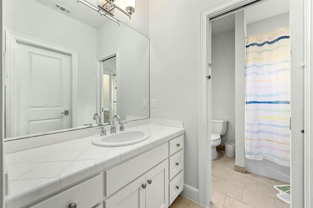 bathroom featuring tile patterned floors, vanity, and toilet