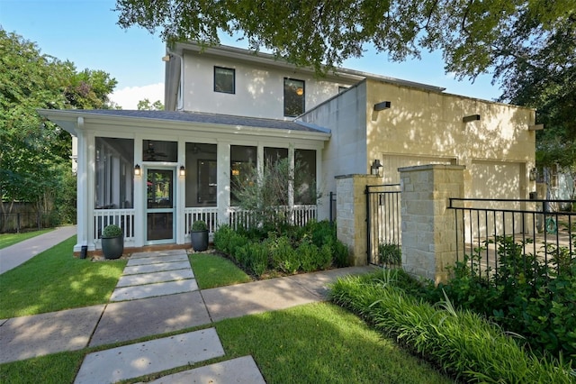 view of front of house featuring a front lawn and a sunroom