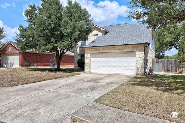 exterior space with a front yard, a garage, and central AC unit