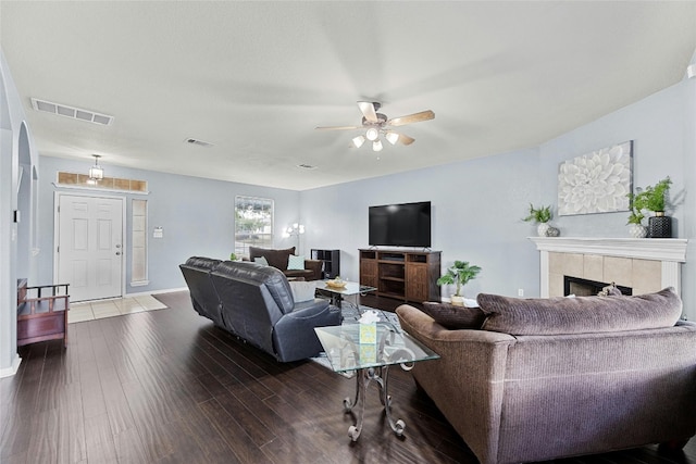 living room featuring a fireplace, dark hardwood / wood-style flooring, and ceiling fan