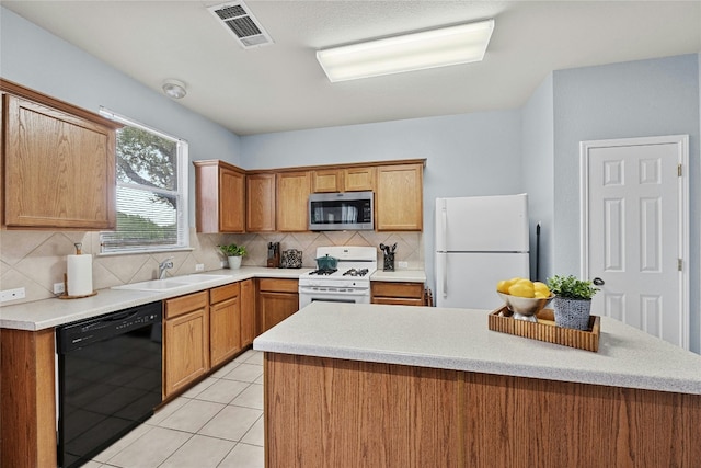 kitchen with light tile patterned floors, sink, white appliances, and decorative backsplash