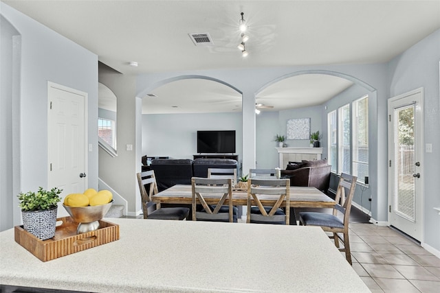 dining room featuring light tile patterned flooring and a tiled fireplace