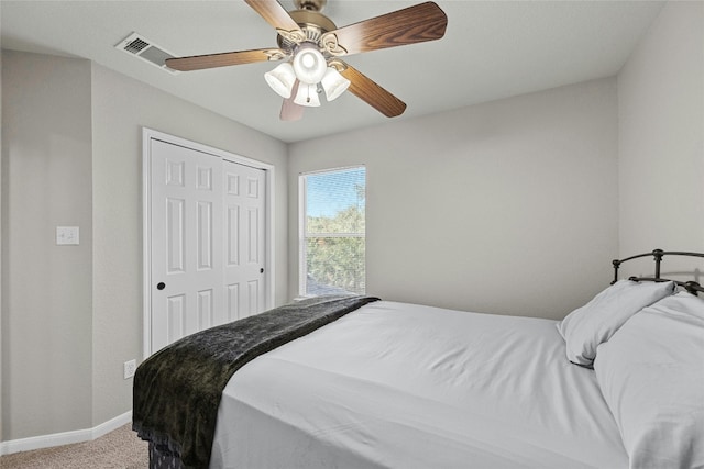 bedroom with ceiling fan, light colored carpet, and a closet