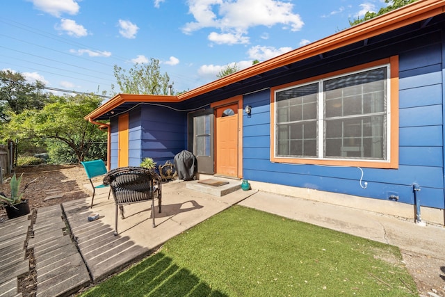 view of exterior entry with a patio area