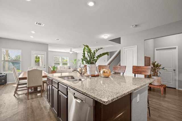 kitchen featuring dark hardwood / wood-style flooring, dishwasher, an island with sink, and sink