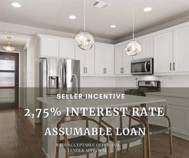 kitchen featuring decorative light fixtures, stainless steel appliances, white cabinets, and dark hardwood / wood-style flooring