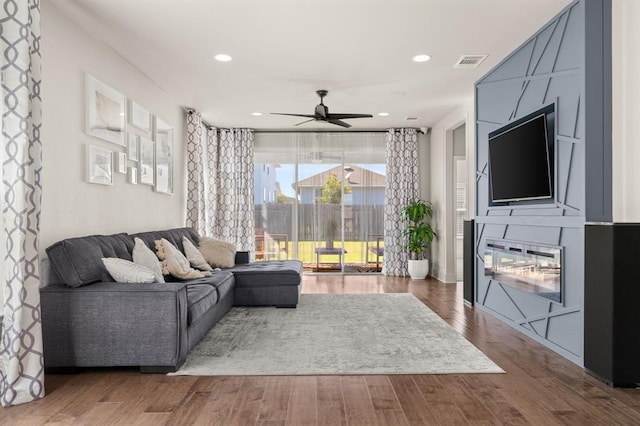 living room with wood-type flooring and ceiling fan