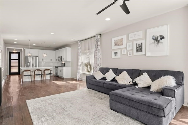 living room featuring hardwood / wood-style floors, ceiling fan, and a wealth of natural light