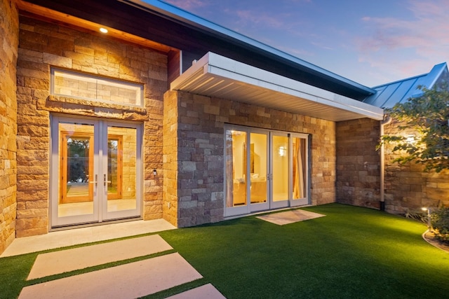 exterior entry at dusk with french doors and a yard