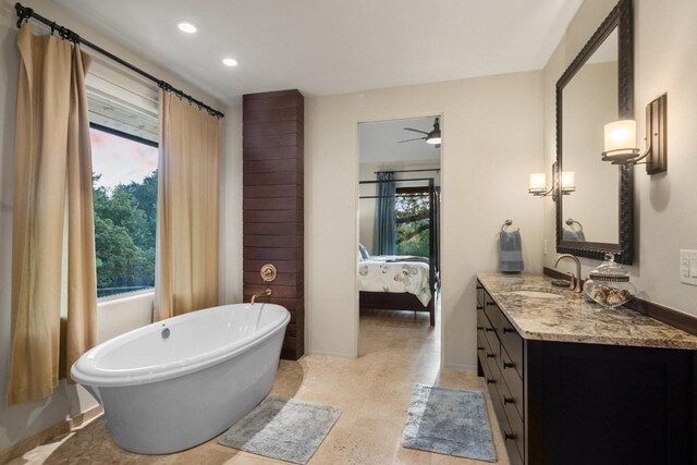 bathroom with vanity, a tub, and ceiling fan