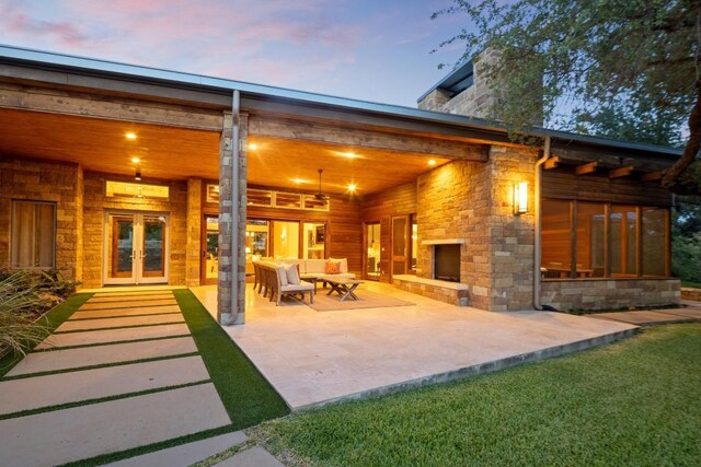 patio terrace at dusk with a lawn and french doors