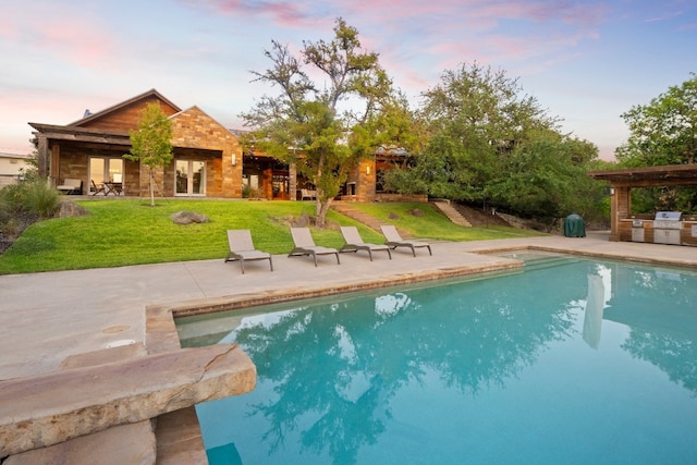 pool at dusk with a lawn and a patio