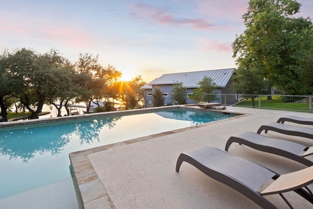 pool at dusk with a patio