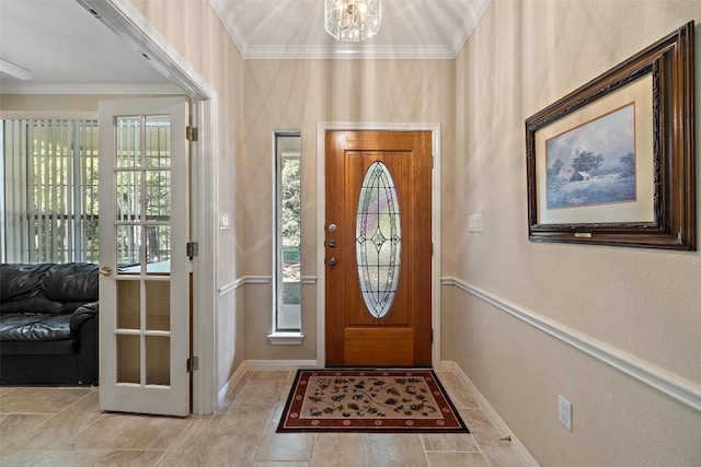 entryway featuring a notable chandelier, plenty of natural light, and ornamental molding