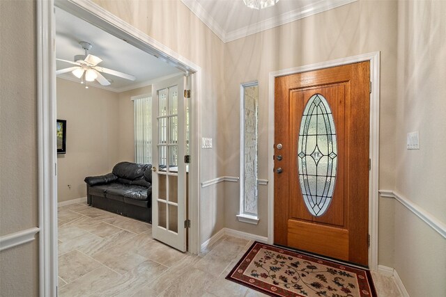 entryway with ceiling fan and crown molding