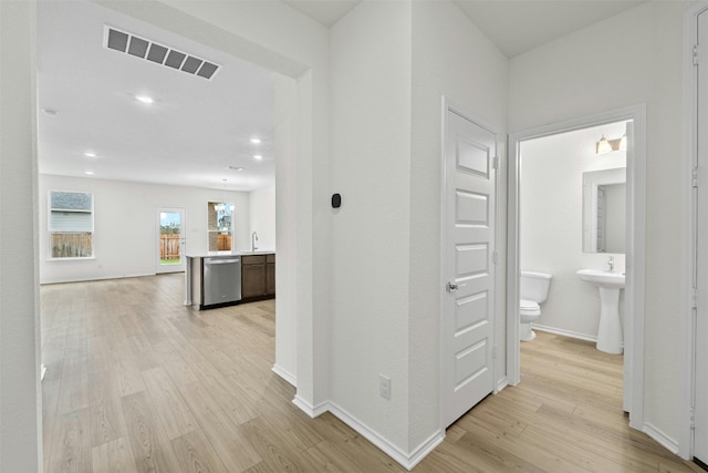 1721 Tin Can Trl, Georgetown, TX 78628 - hall featuring light wood finished floors, baseboards, a sink, and recessed lighting