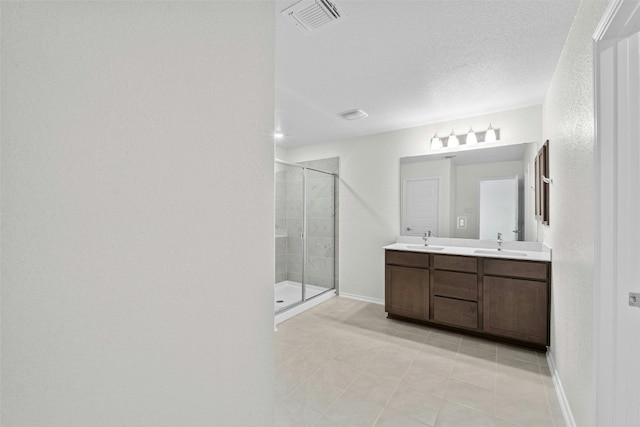 1721 Tin Can Trl, Georgetown, TX 78628 - bathroom with a stall shower, double vanity, baseboards, tile patterned flooring, and a textured ceiling