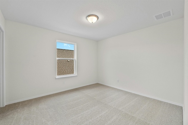 carpeted empty room featuring a textured ceiling