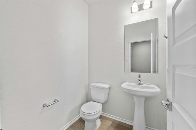 bathroom featuring sink, hardwood / wood-style floors, and toilet