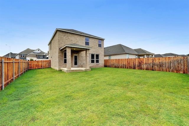 back of property with a patio area and a lawn