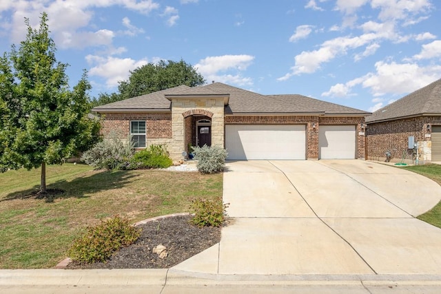 view of front of home with brick siding, a front lawn, roof with shingles, a garage, and driveway