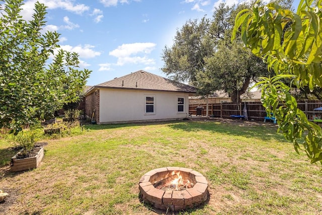 view of yard with a fire pit and fence