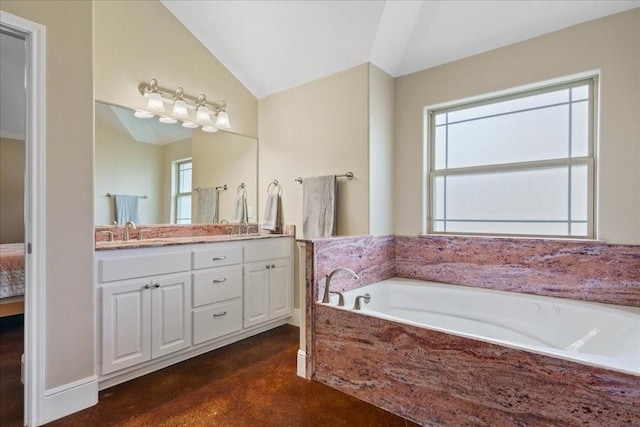 bathroom featuring plenty of natural light, lofted ceiling, vanity, and tiled bath