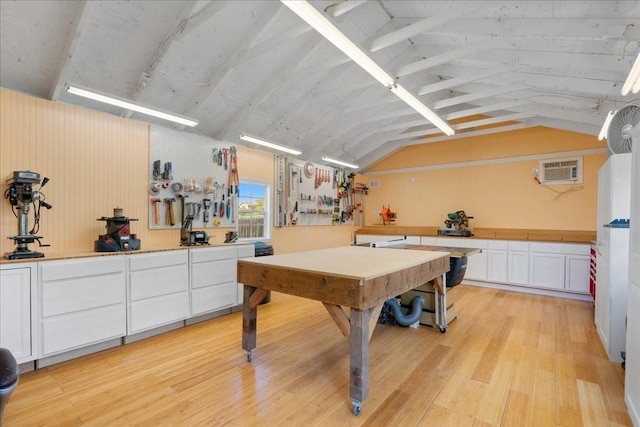 rec room featuring vaulted ceiling, a wall mounted air conditioner, and light wood-type flooring