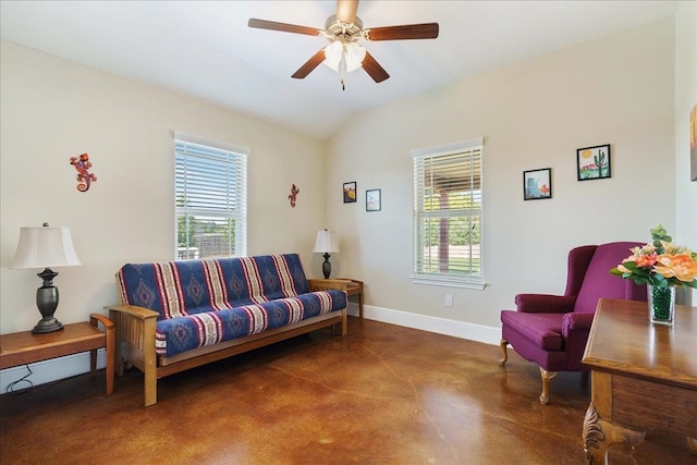 living area featuring ceiling fan, lofted ceiling, a wealth of natural light, and concrete flooring