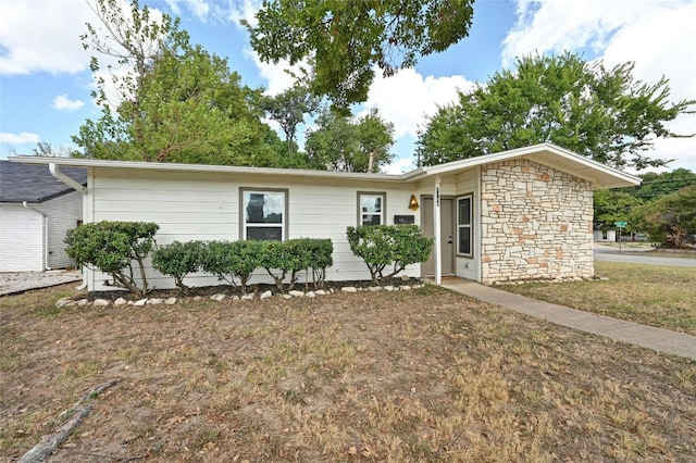 1130 Gardner Rd, Austin, TX 78721 - ranch-style home featuring stone siding and a front lawn