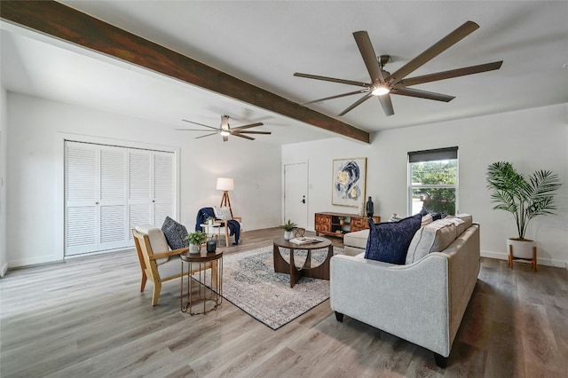 living room with hardwood / wood-style flooring, beamed ceiling, and ceiling fan