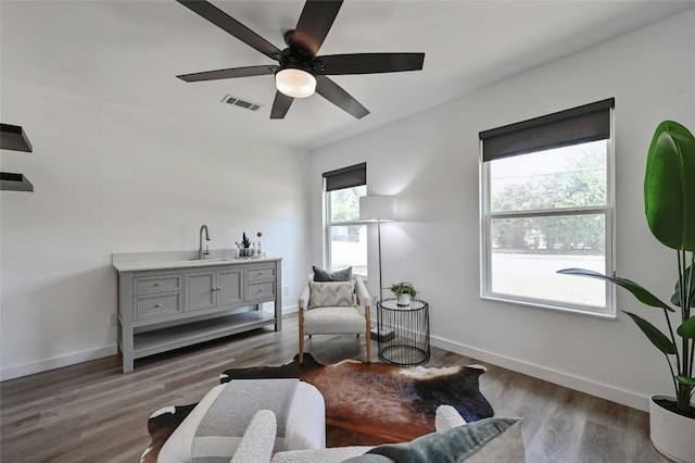 sitting room with dark wood-type flooring and ceiling fan