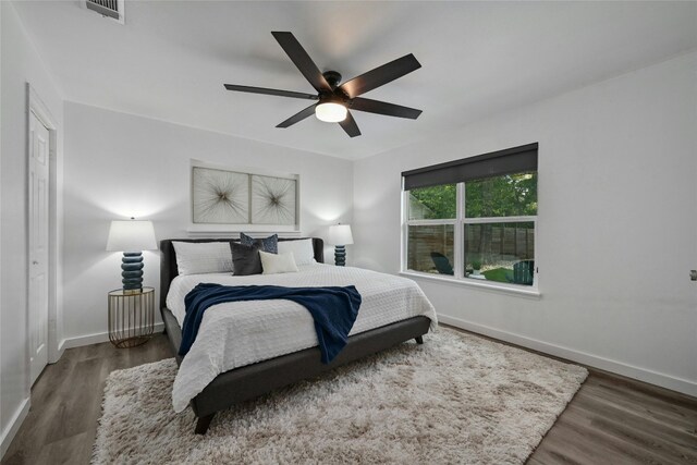 bedroom with dark hardwood / wood-style flooring and ceiling fan