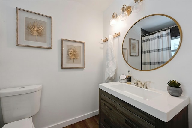 bathroom with hardwood / wood-style floors, curtained shower, vanity, and toilet